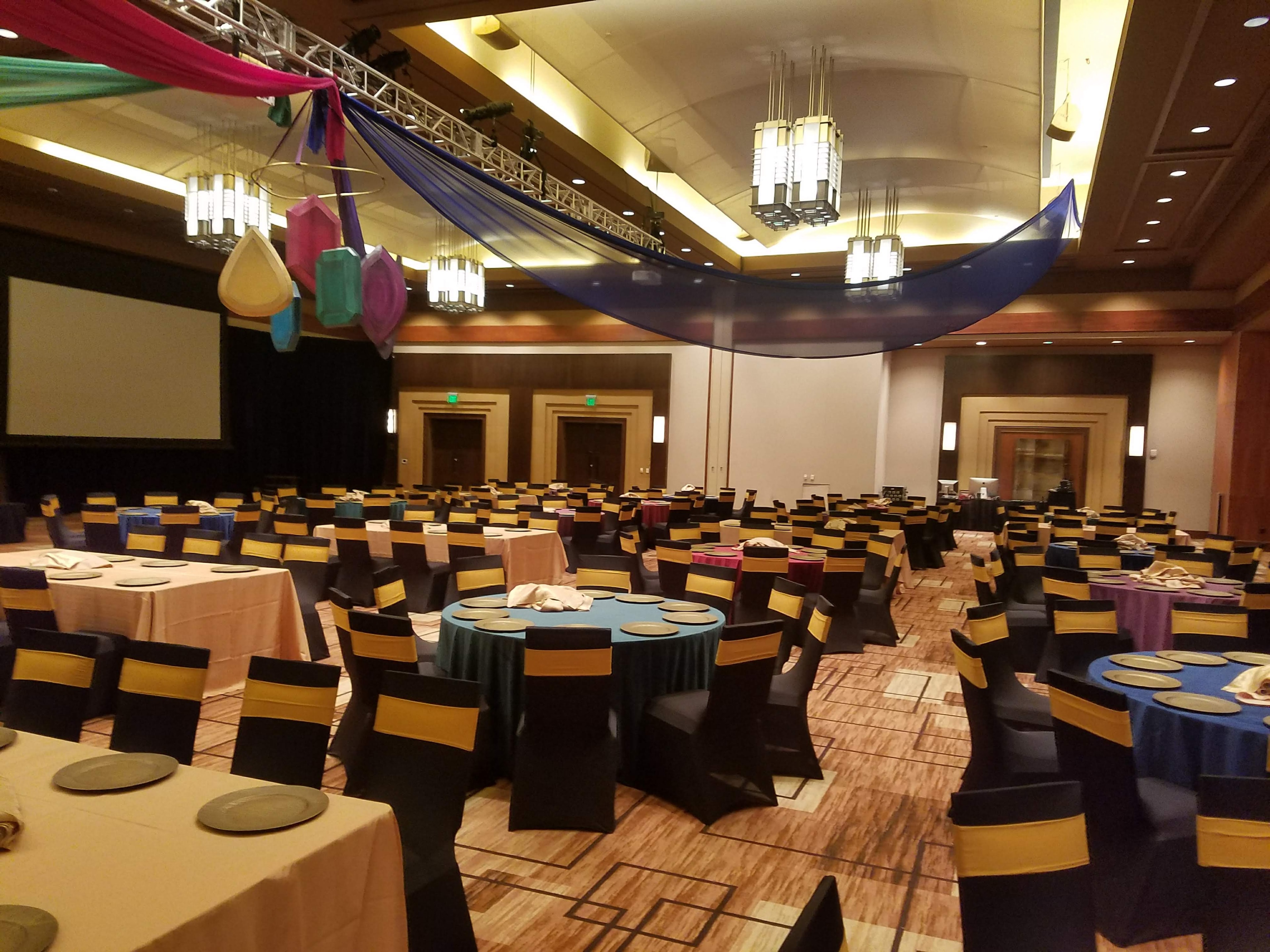 Vibrant multi-color tablecloths and draped ceiling décor