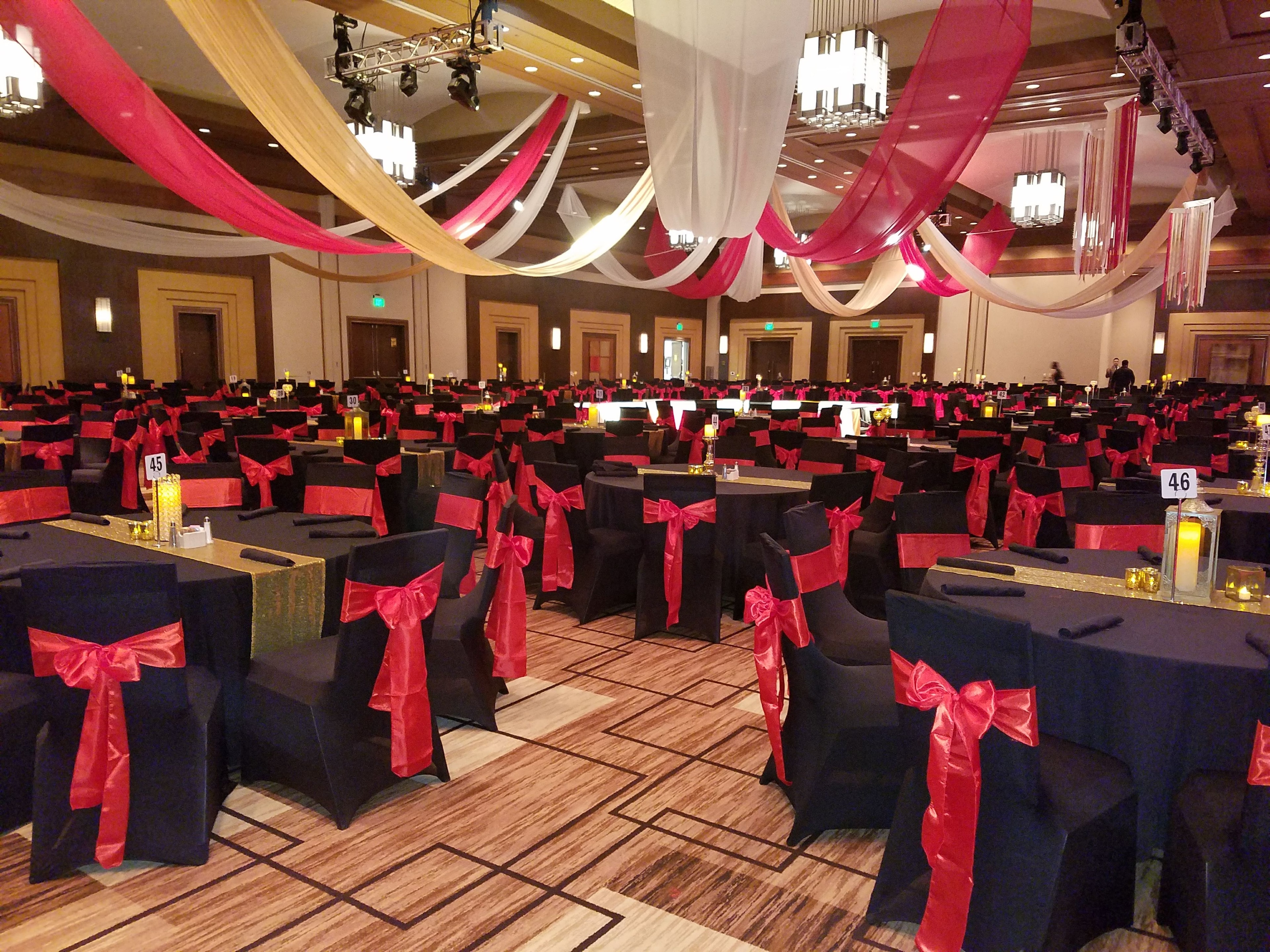 Grand ballroom with crimson sashes and draped ceiling linens