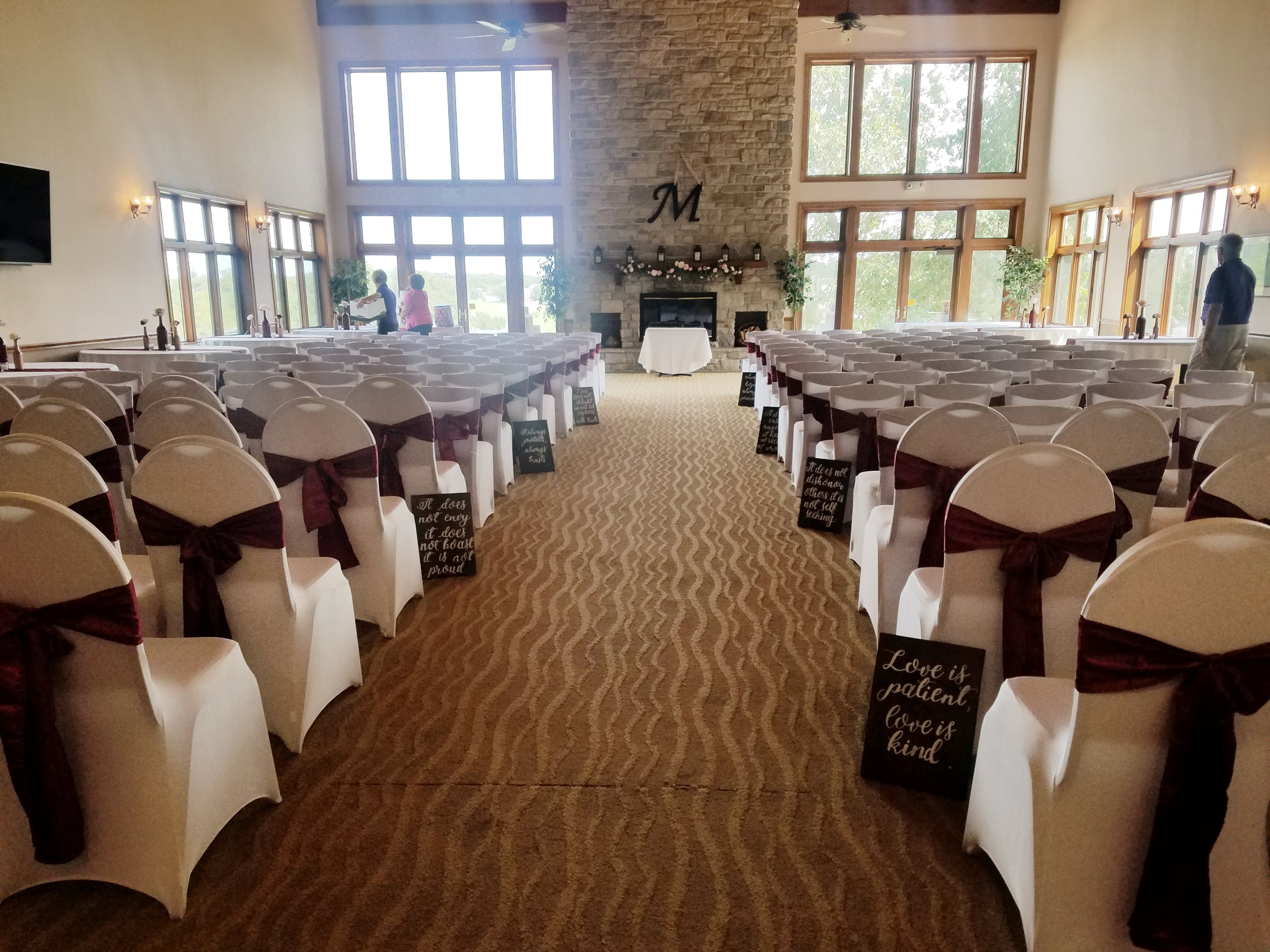 Romantic ceremony setup with burgundy sashes and chalkboard signs