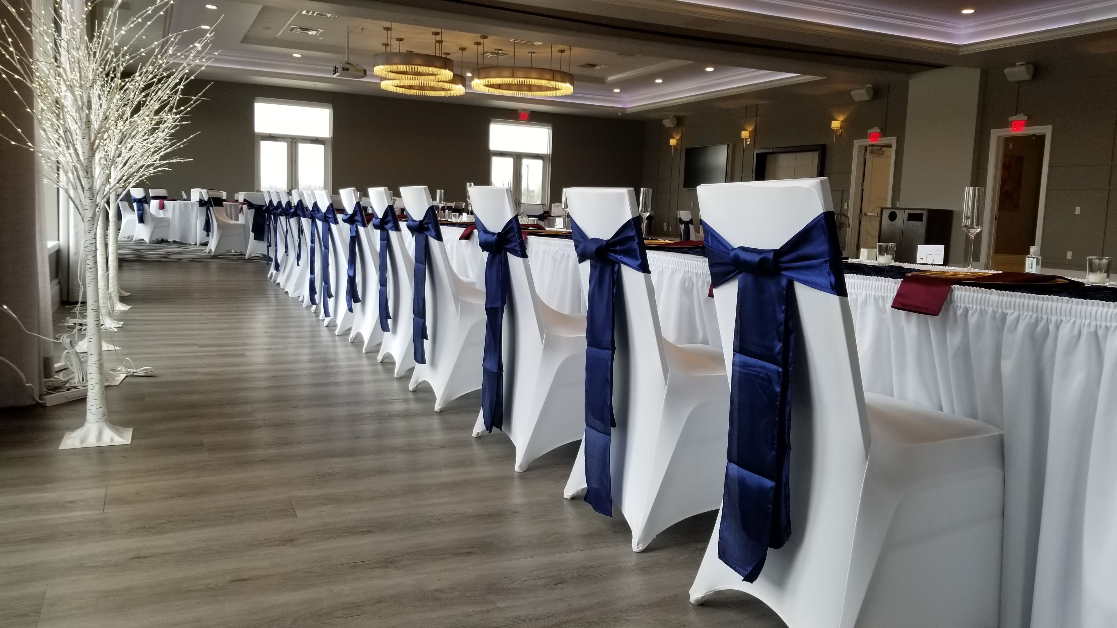 Head table with white spandex covers and navy satin sashes
