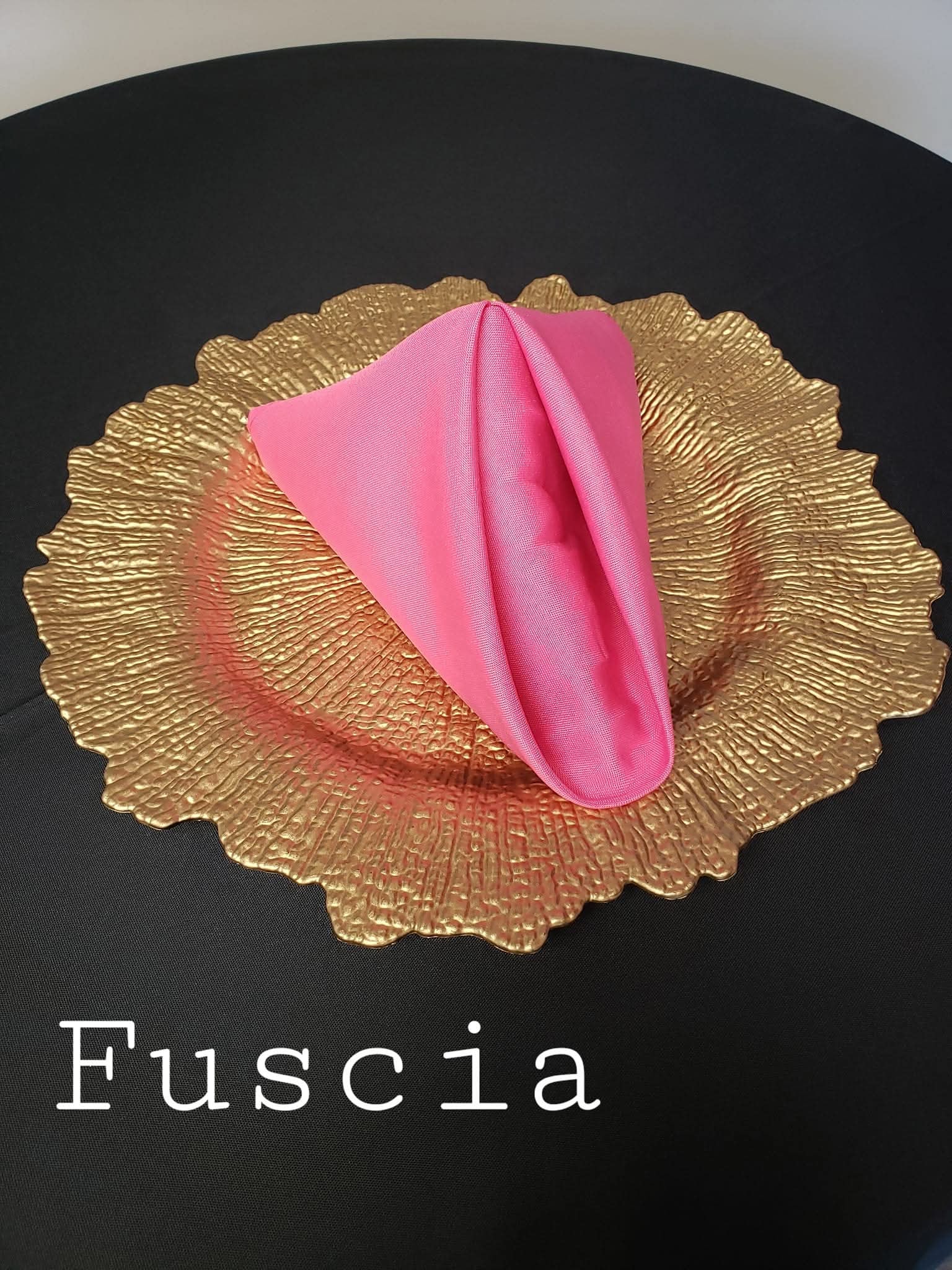 Beautifully folded fabric napkin on a gold charger plate