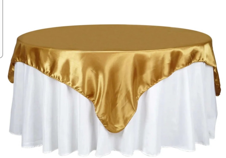 Elegant round table with gold overlay and white tablecloth skirt
